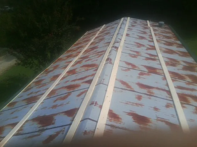 Rusted metal roof panels with new wood purlins before replacement — Storm Damage Roof Repair in Lakota by Roofing Brothers