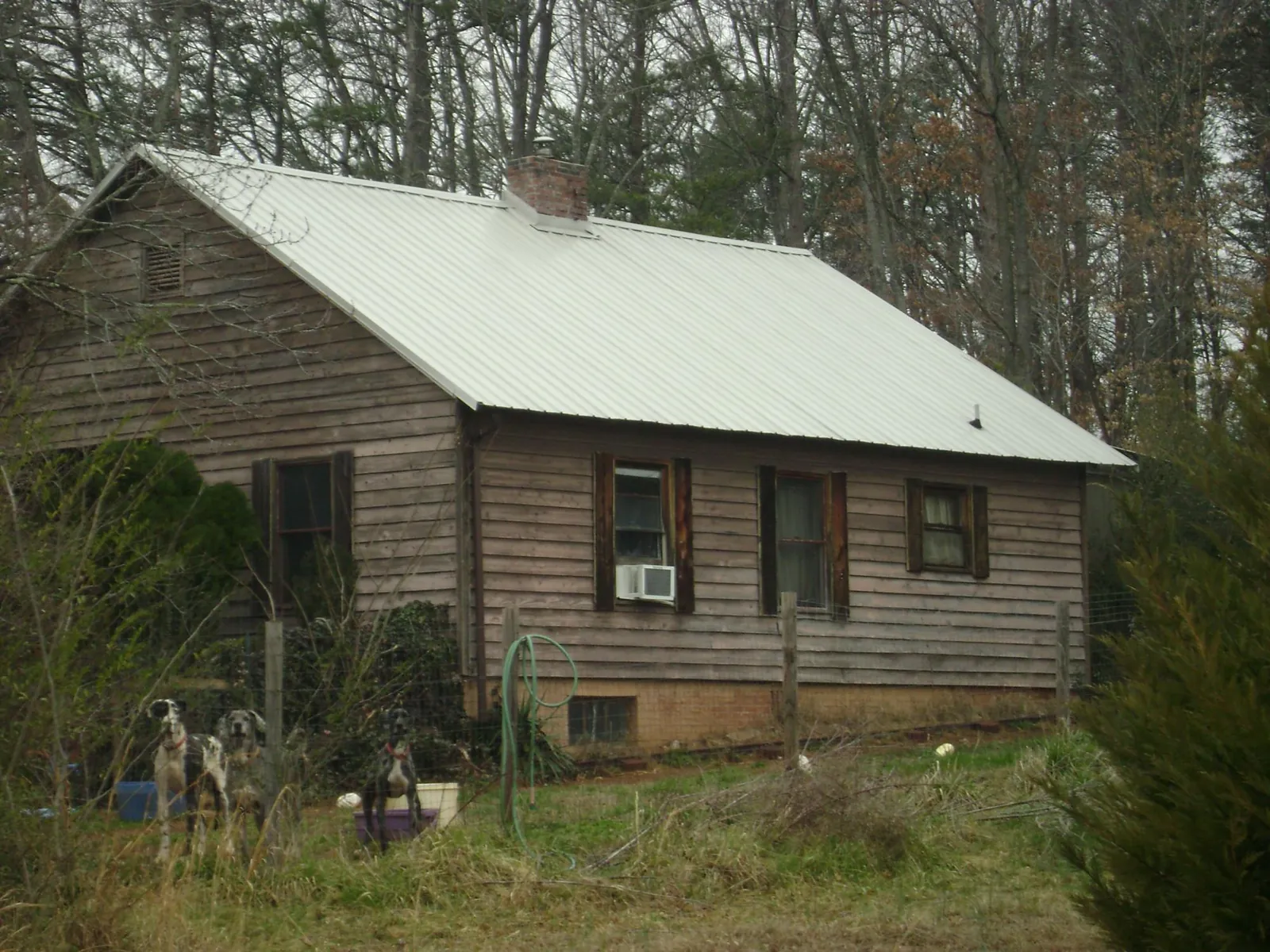 White metal roof on an old wood sided farmhouse, from a Metal Roof Installation job in Lakota